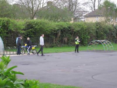 Youths with motorbike on the playground at St.Luke's School being stopped by PCSOs