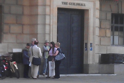 Huddle of six people outside the Guildhall in Cambridge. MP Huppert in a white suit. 